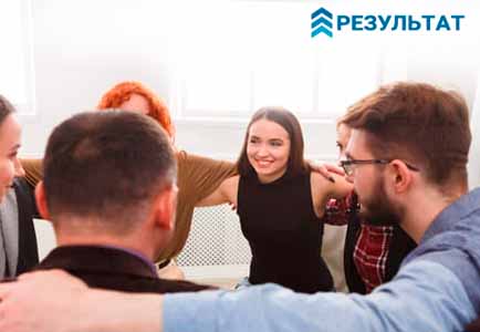 Группа людей держатся за руки на тренинге