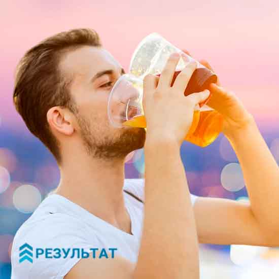 Мужчина пьёт пиво из стакана